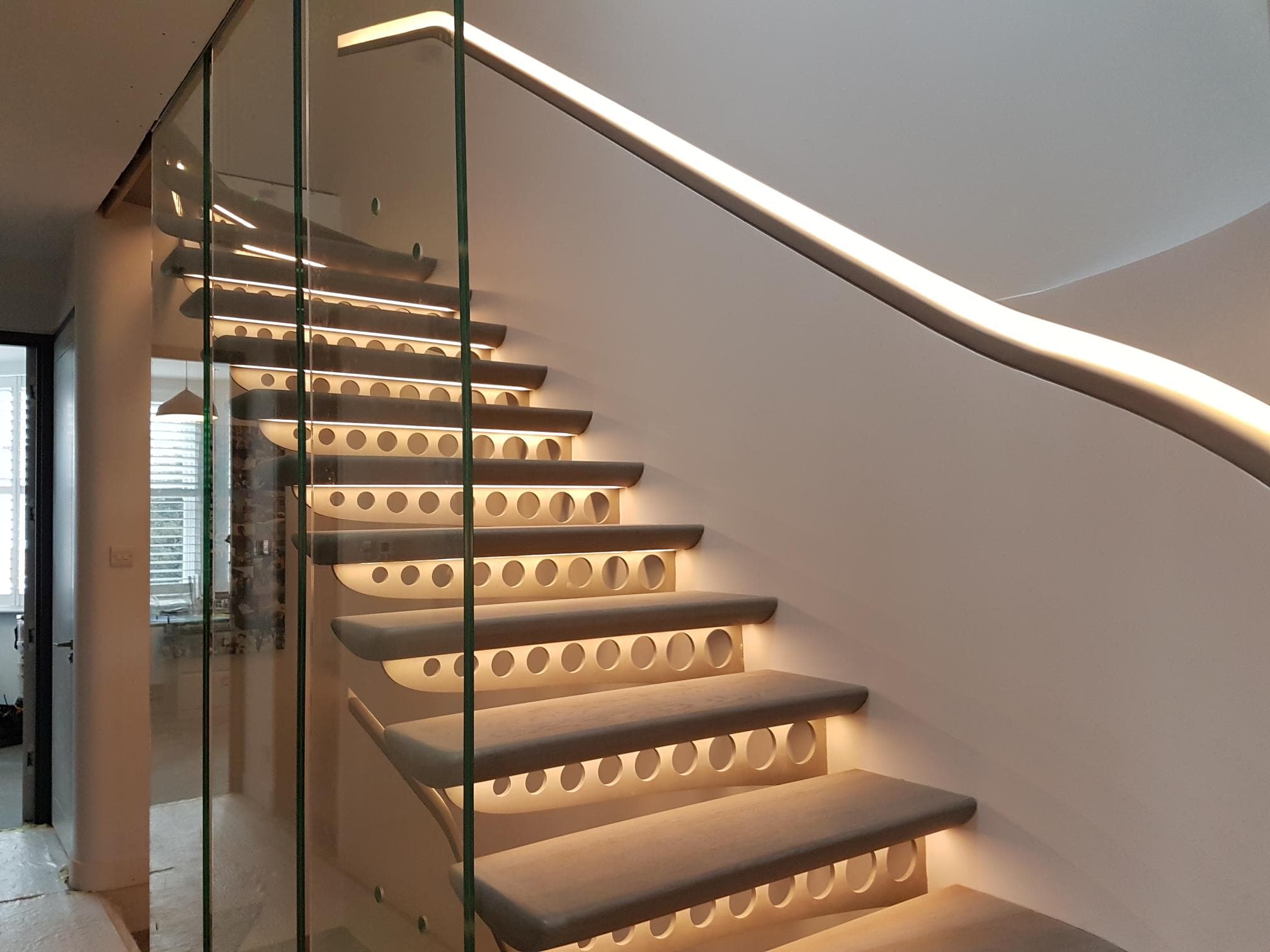 Staircase with glass balustrade and LED strip handrail